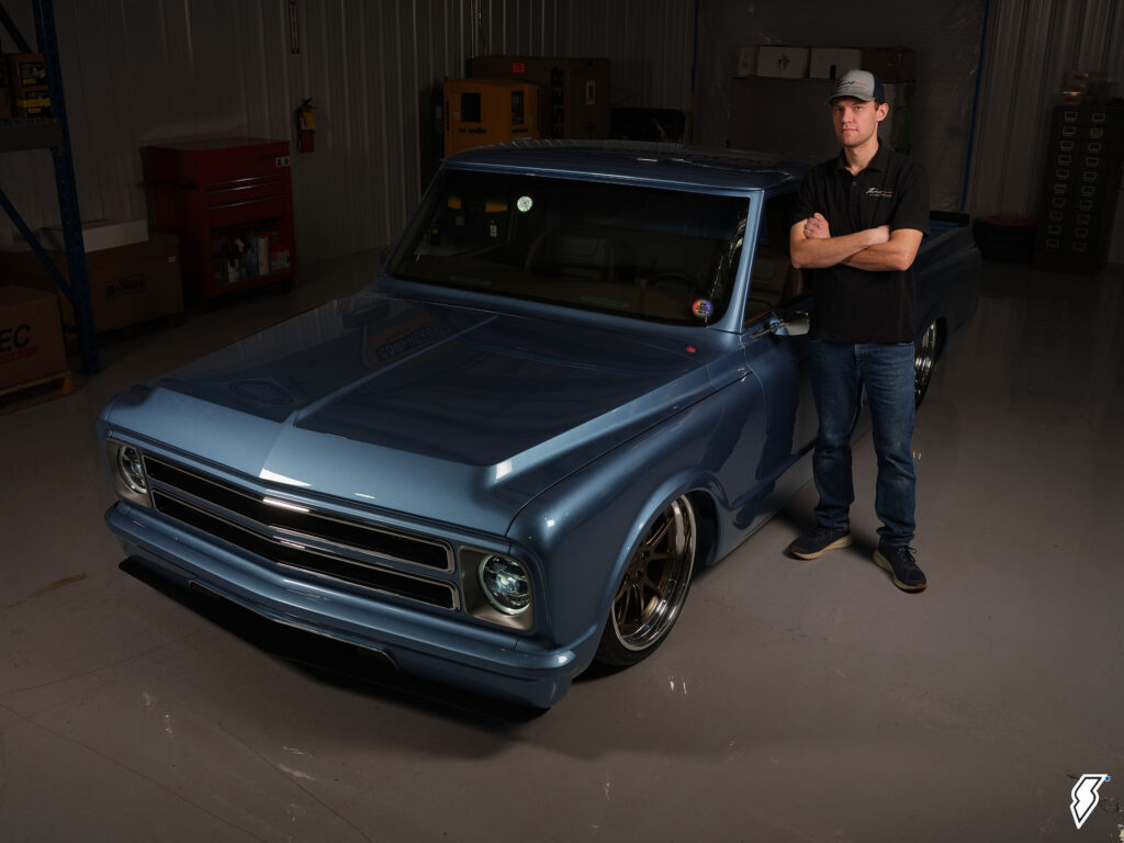 man standing next to a custom chevy truck
