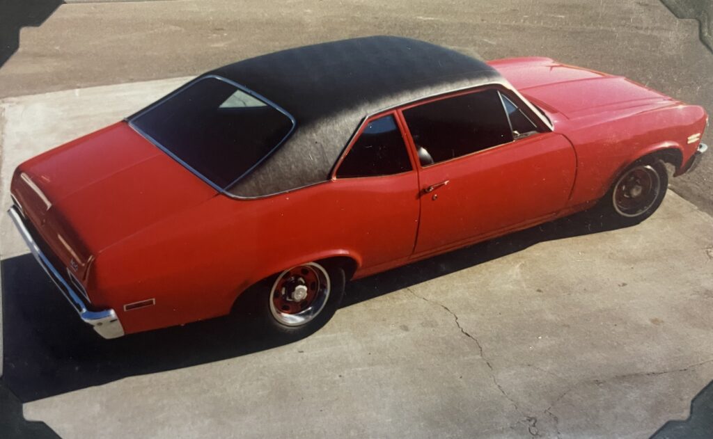 red chevy nova with a black vinyl roof